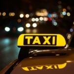 yellow black sign taxi placed top car night